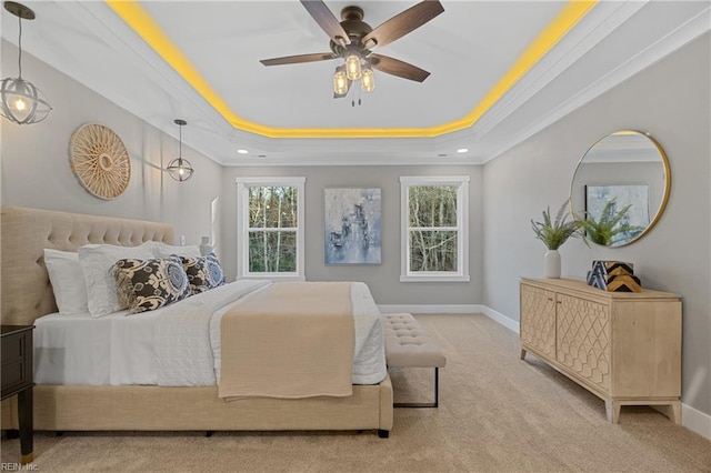 carpeted bedroom featuring a raised ceiling, ceiling fan, and crown molding