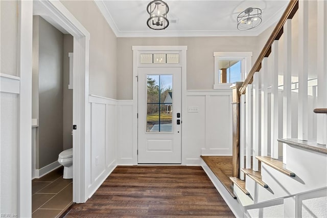 entrance foyer featuring crown molding, dark hardwood / wood-style flooring, and a chandelier