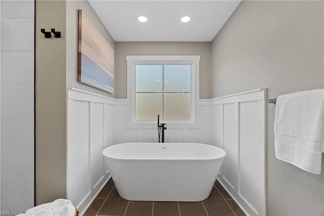 bathroom featuring tile patterned flooring and a bath