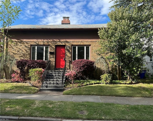 1049 Brandon Ave, Norfolk, VA 23507 - view of front facade with a chimney, a front lawn, and brick siding