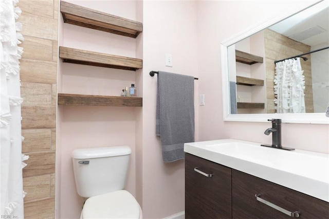 bathroom featuring curtained shower, vanity, and toilet