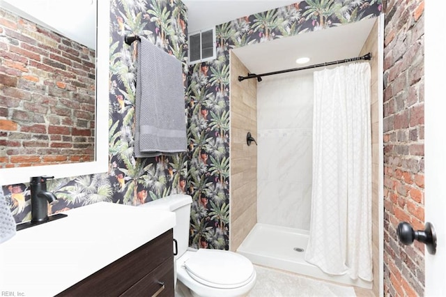 bathroom featuring walk in shower, vanity, brick wall, and toilet