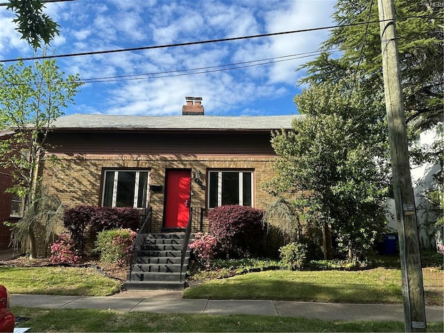 1049 Brandon Ave, Norfolk, VA 23507 - view of front facade with a chimney, a front lawn, and brick siding