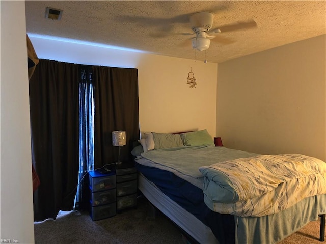 carpeted bedroom featuring ceiling fan and a textured ceiling