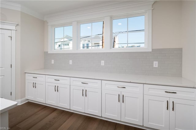 kitchen featuring plenty of natural light, dark hardwood / wood-style flooring, white cabinetry, and ornamental molding