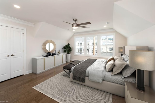 bedroom featuring a closet, dark hardwood / wood-style floors, ceiling fan, and lofted ceiling