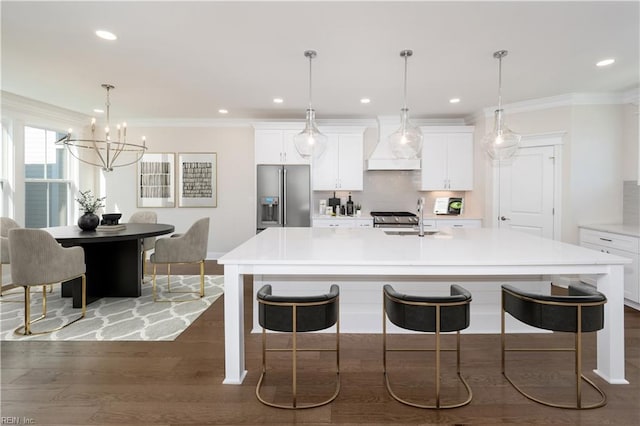 kitchen featuring white cabinets, a spacious island, custom range hood, and appliances with stainless steel finishes