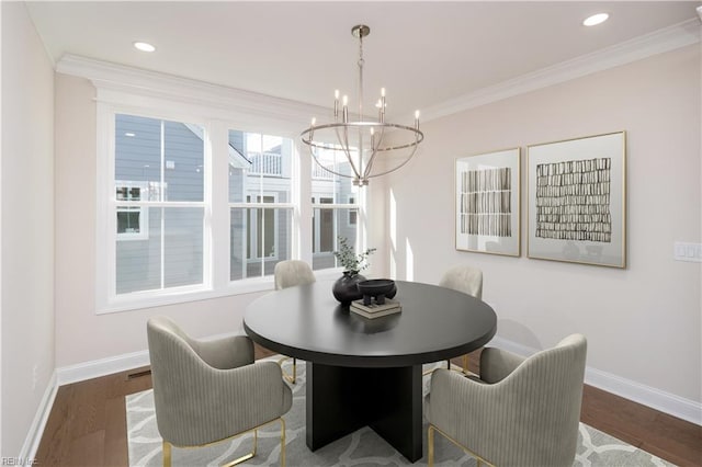 dining area with a notable chandelier, dark hardwood / wood-style flooring, and crown molding