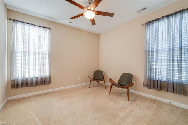 sitting room featuring light carpet and ceiling fan