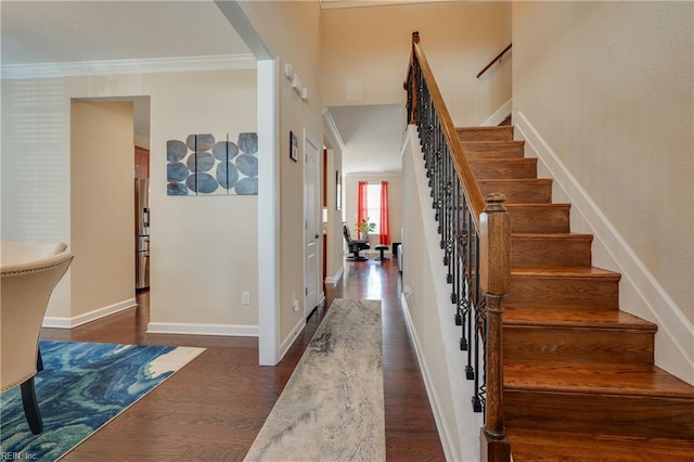 stairway with wood-type flooring and ornamental molding