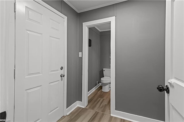 bathroom featuring crown molding, hardwood / wood-style floors, and toilet