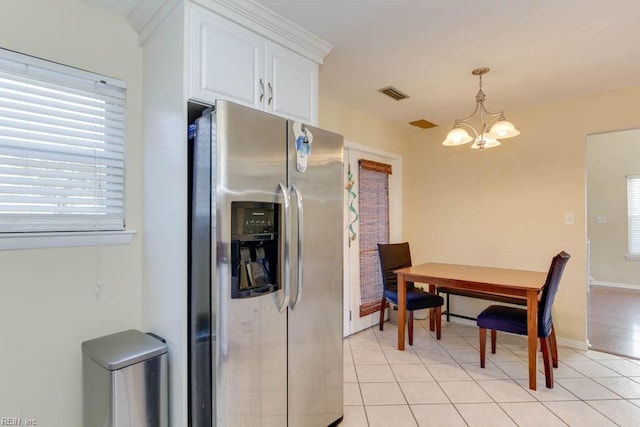 kitchen featuring an inviting chandelier, white cabinets, stainless steel refrigerator with ice dispenser, pendant lighting, and light tile patterned floors