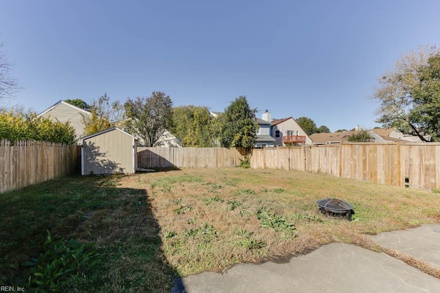 view of yard with a shed and an outdoor fire pit