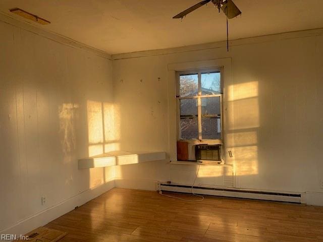 spare room with ornamental molding, a baseboard heating unit, hardwood / wood-style floors, and ceiling fan