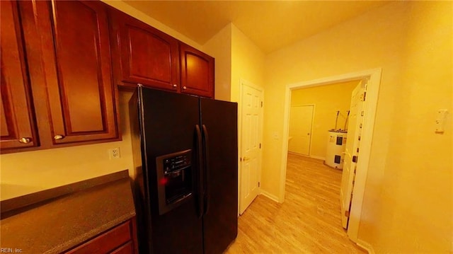 kitchen with light hardwood / wood-style flooring and black fridge