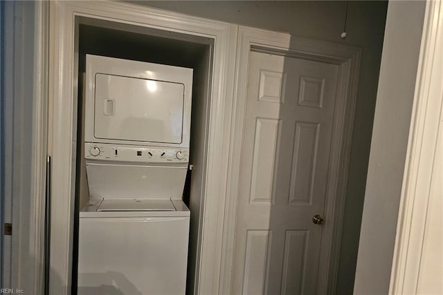 clothes washing area featuring stacked washer and clothes dryer