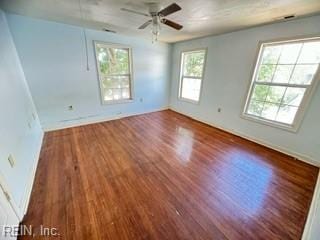 spare room featuring dark hardwood / wood-style floors, a healthy amount of sunlight, and ceiling fan