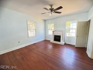 unfurnished living room with plenty of natural light, dark wood-type flooring, and ceiling fan