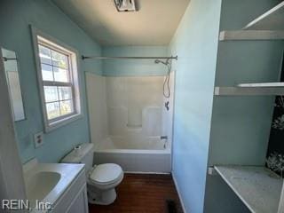 full bathroom featuring washtub / shower combination, hardwood / wood-style floors, vanity, and toilet