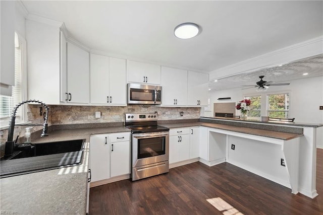 kitchen with stainless steel appliances, white cabinetry, dark wood-type flooring, and sink