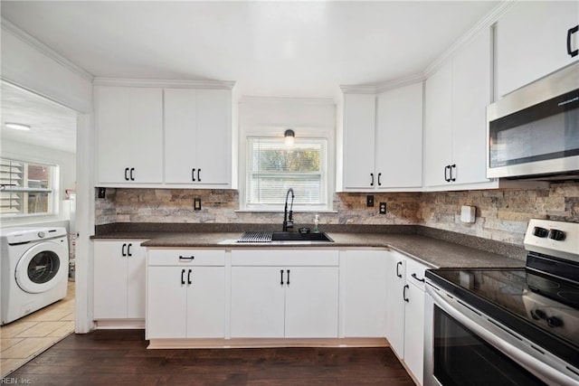 kitchen featuring washer / clothes dryer, white cabinetry, sink, and appliances with stainless steel finishes