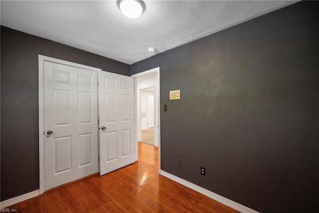 unfurnished bedroom featuring hardwood / wood-style floors and a closet