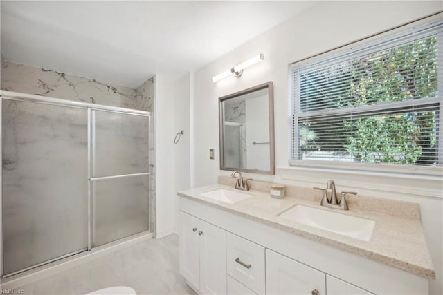 bathroom with plenty of natural light, vanity, and a shower with shower door