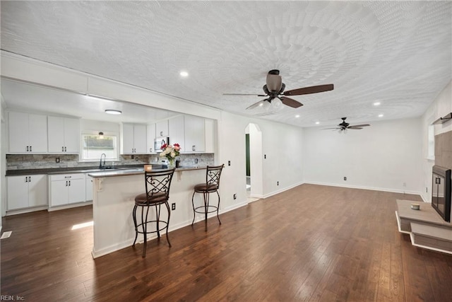 kitchen with ceiling fan, white cabinets, dark wood-type flooring, and a textured ceiling