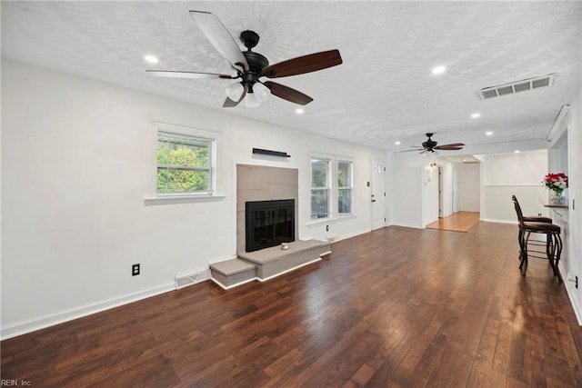 unfurnished living room with ceiling fan, a textured ceiling, and hardwood / wood-style flooring