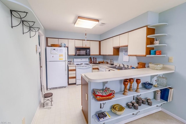 kitchen with kitchen peninsula, white appliances, and sink