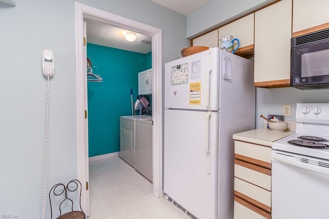 kitchen with white cabinets, washing machine and dryer, white appliances, and a textured ceiling