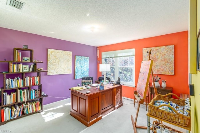 home office with light colored carpet and a textured ceiling