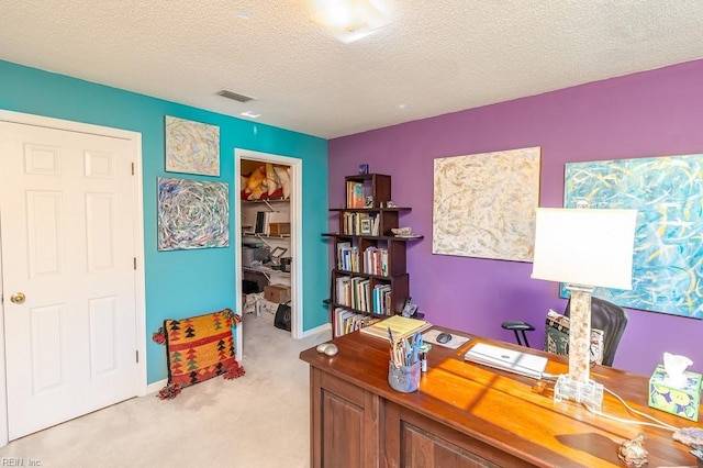 home office with a textured ceiling and light carpet