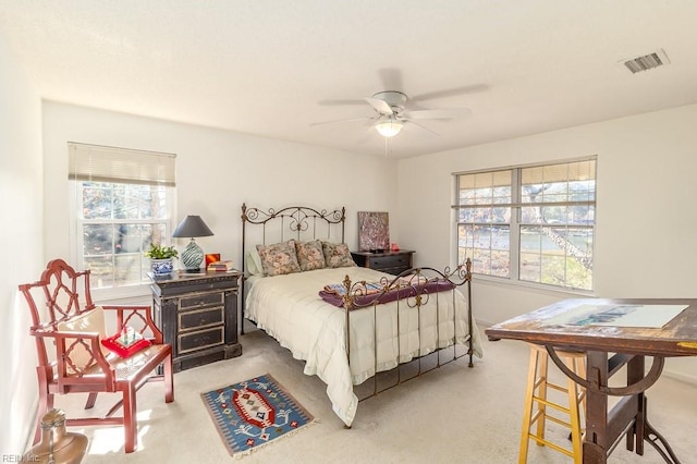 bedroom featuring carpet, ceiling fan, and multiple windows