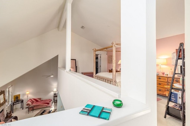 bedroom with vaulted ceiling with beams and light carpet