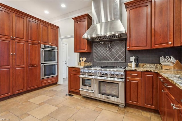 kitchen featuring wall chimney exhaust hood, stainless steel appliances, light stone counters, backsplash, and ornamental molding