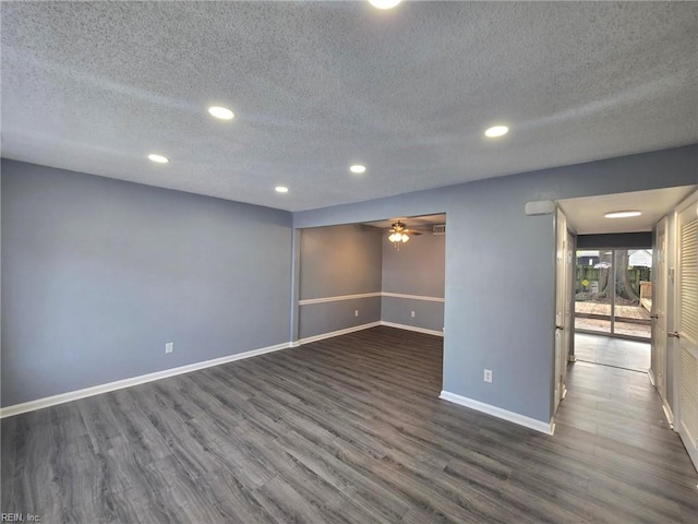 spare room with a textured ceiling and dark wood-type flooring