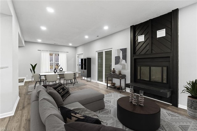 living room featuring hardwood / wood-style floors and a large fireplace