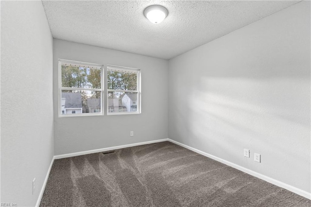 unfurnished room with a textured ceiling and carpet floors