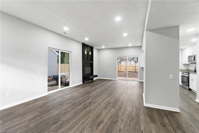 unfurnished living room with dark hardwood / wood-style flooring and a textured ceiling