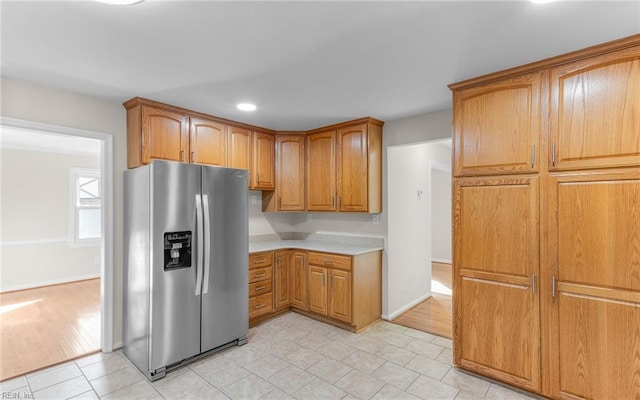 kitchen with stainless steel fridge with ice dispenser and light hardwood / wood-style floors