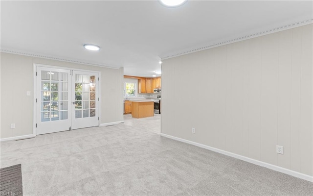 unfurnished living room with light carpet and french doors