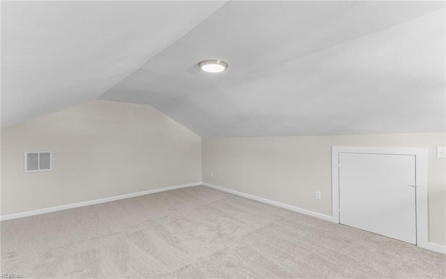 bonus room with light carpet and lofted ceiling