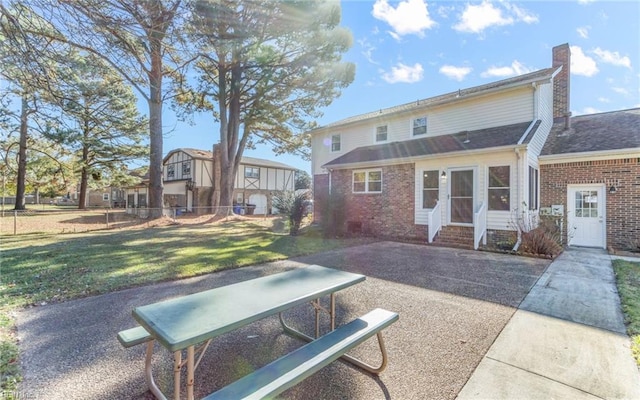 back of property featuring a lawn and a patio