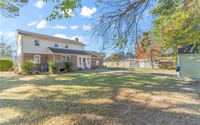 rear view of property featuring a yard, cooling unit, a patio, and a storage shed