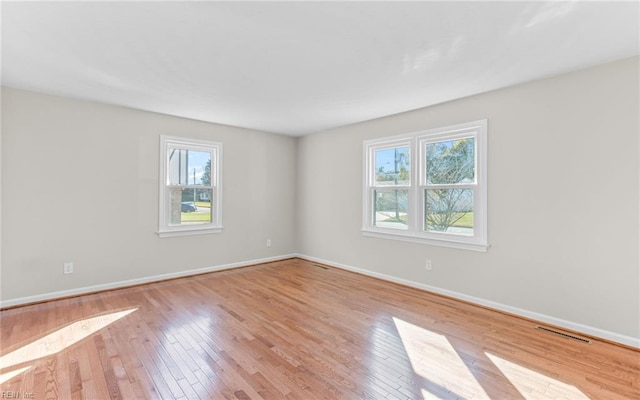 unfurnished room with light hardwood / wood-style flooring and a healthy amount of sunlight