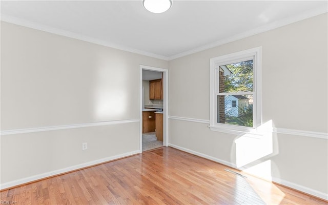 empty room with light wood-type flooring and ornamental molding