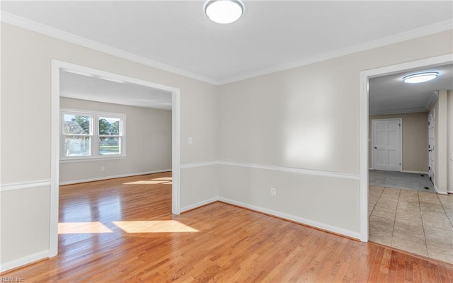 empty room featuring crown molding and light hardwood / wood-style flooring