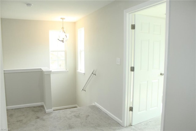 stairway featuring carpet floors and an inviting chandelier