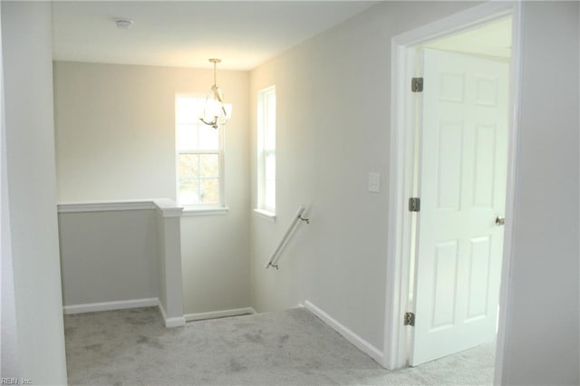 staircase with carpet floors and a chandelier